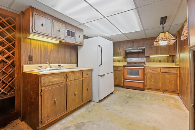 kitchen with range with electric cooktop, wooden walls, sink, pendant lighting, and white refrigerator