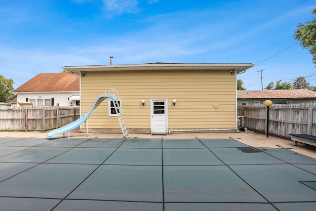 rear view of house with a covered pool and a patio area