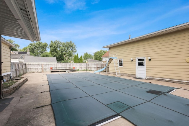 view of pool with a patio, a diving board, and a water slide