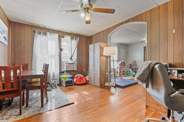 dining room featuring wood walls, ceiling fan, and hardwood / wood-style flooring