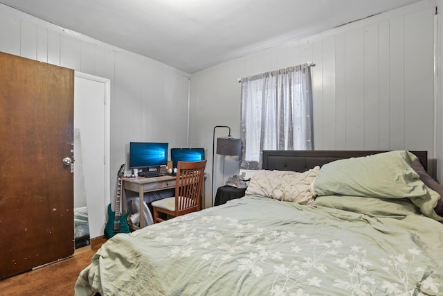 carpeted bedroom with wooden walls