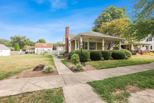 bungalow with covered porch and a front yard