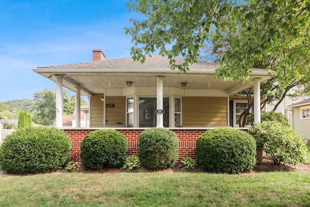 rear view of property with a lawn and a porch