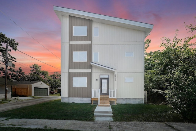 view of front of home featuring a garage, an outbuilding, and a yard