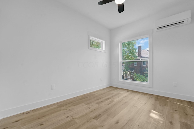 empty room featuring an AC wall unit, ceiling fan, and light hardwood / wood-style flooring