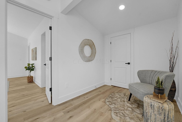 living area with light hardwood / wood-style flooring and vaulted ceiling