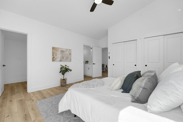 bedroom featuring ceiling fan, two closets, high vaulted ceiling, and light hardwood / wood-style flooring