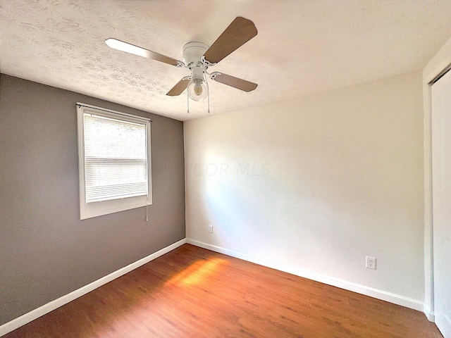 spare room featuring wood-type flooring and ceiling fan