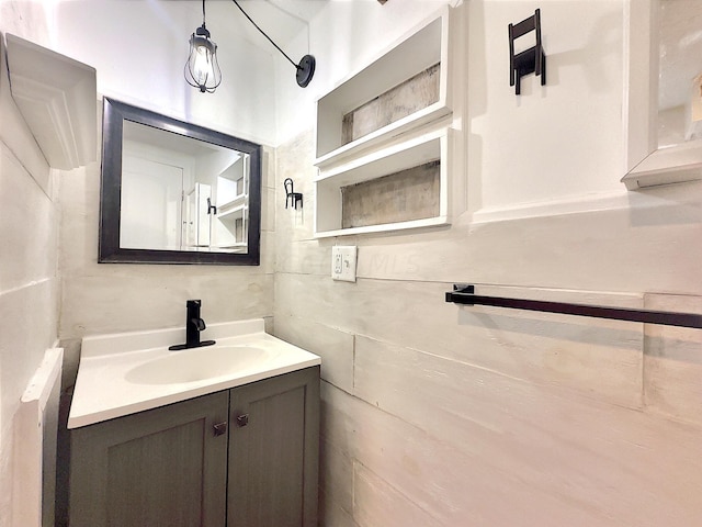 bathroom with vanity and tile walls