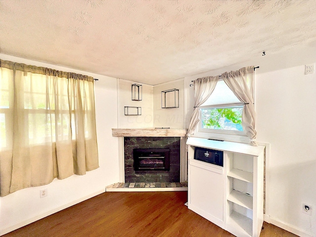 unfurnished living room with dark hardwood / wood-style floors and a textured ceiling