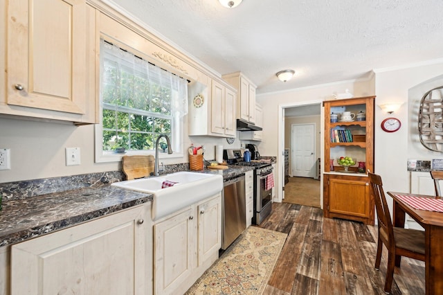 kitchen featuring dark wood-type flooring, crown molding, sink, a textured ceiling, and appliances with stainless steel finishes