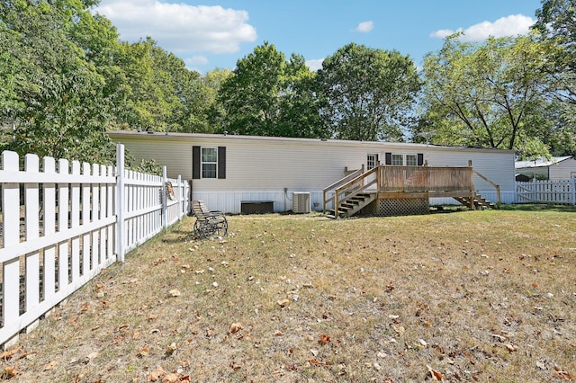 rear view of property featuring a yard, a deck, and cooling unit