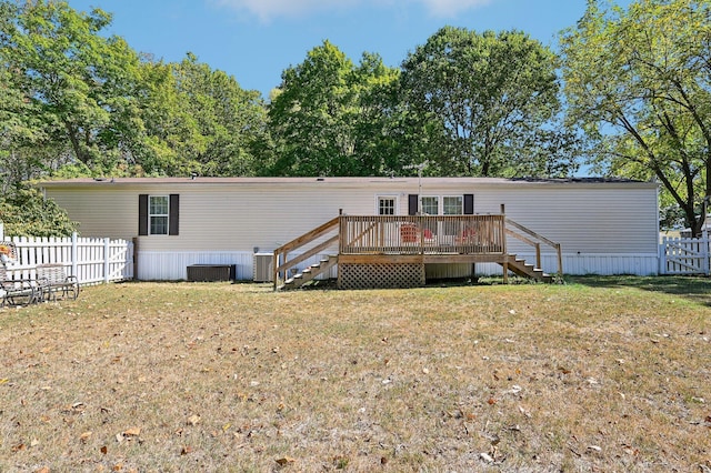 back of house with a yard, a wooden deck, and central air condition unit