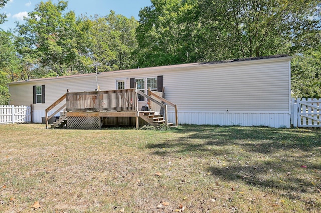 rear view of property with a yard and a deck