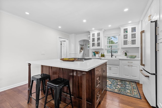 kitchen with white cabinetry, a center island, white fridge, and dark wood-type flooring