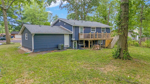 rear view of house with a lawn, a wooden deck, and central AC