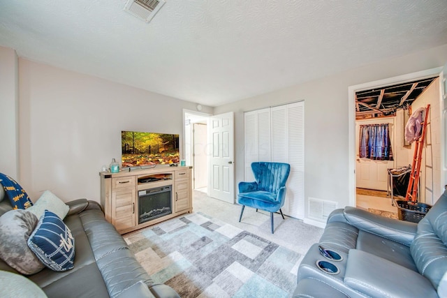 living room with a textured ceiling and light colored carpet