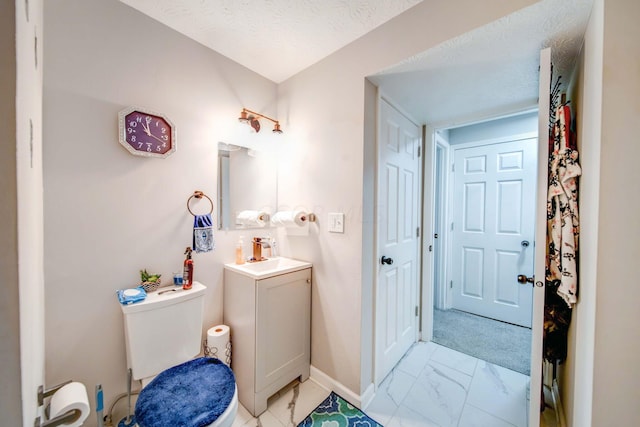 bathroom featuring vanity, a textured ceiling, and toilet