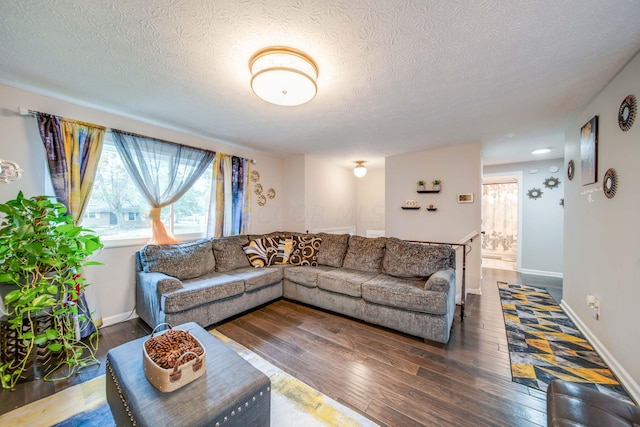 living room featuring a textured ceiling and dark wood-type flooring