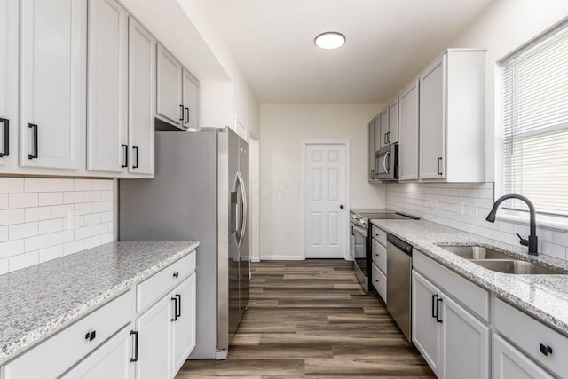 kitchen featuring dark hardwood / wood-style flooring, stainless steel appliances, plenty of natural light, and sink