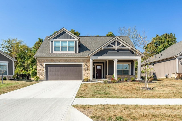 craftsman house with a garage and a front lawn