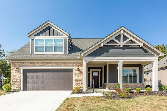 craftsman-style house featuring a front yard, a garage, and covered porch