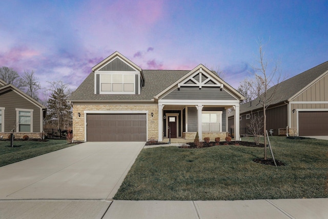 view of front of home with a garage, a yard, and covered porch