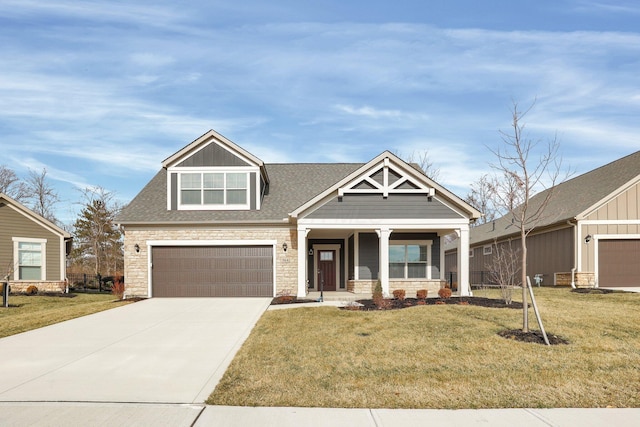 view of front of house with a garage, a front lawn, and covered porch