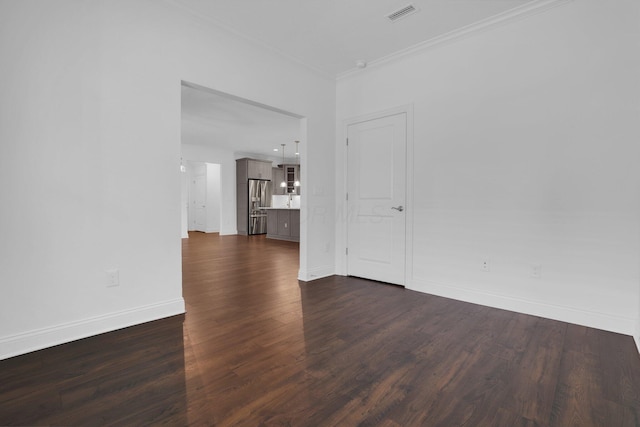 empty room with dark hardwood / wood-style flooring and crown molding