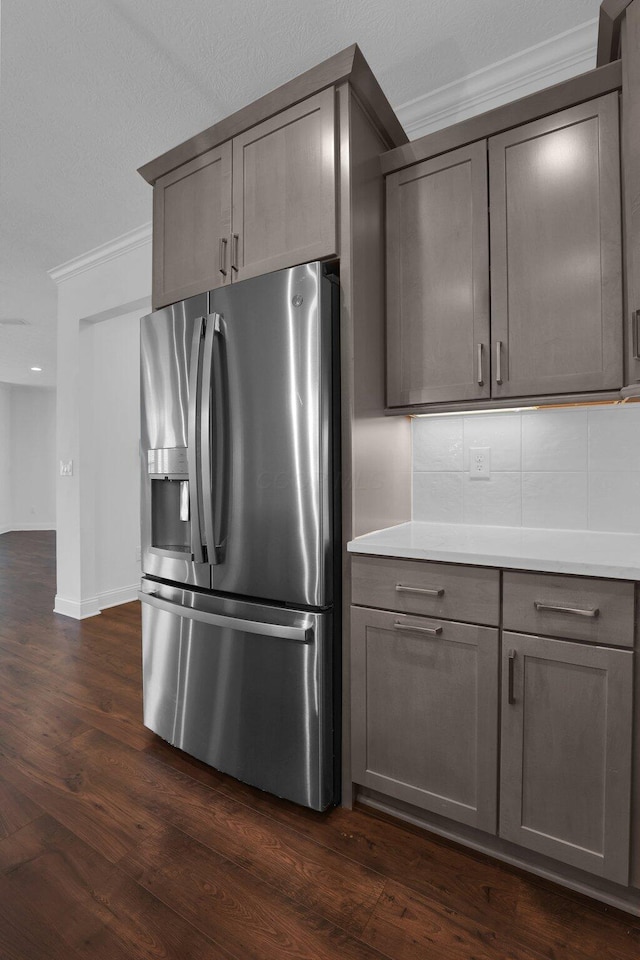 kitchen with crown molding, dark wood-type flooring, backsplash, and stainless steel fridge with ice dispenser