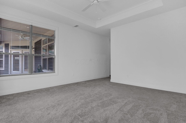 carpeted spare room with crown molding, a tray ceiling, and ceiling fan