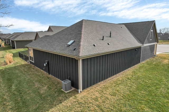 view of side of home featuring cooling unit and a lawn