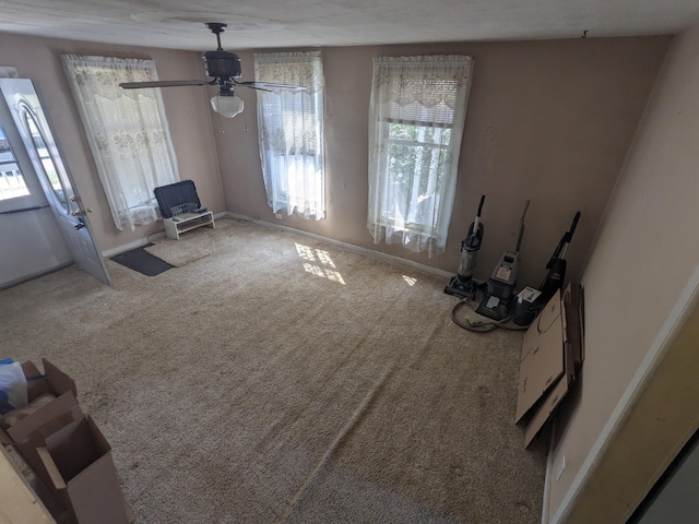 interior space with carpet floors, a wealth of natural light, and ceiling fan