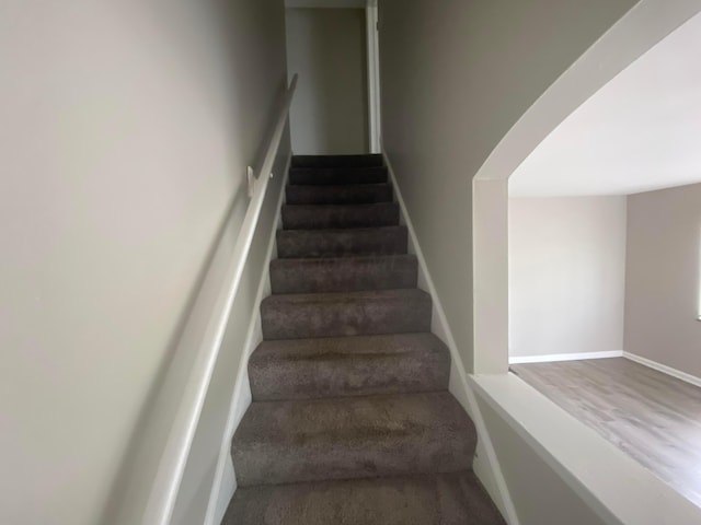 stairs featuring hardwood / wood-style floors