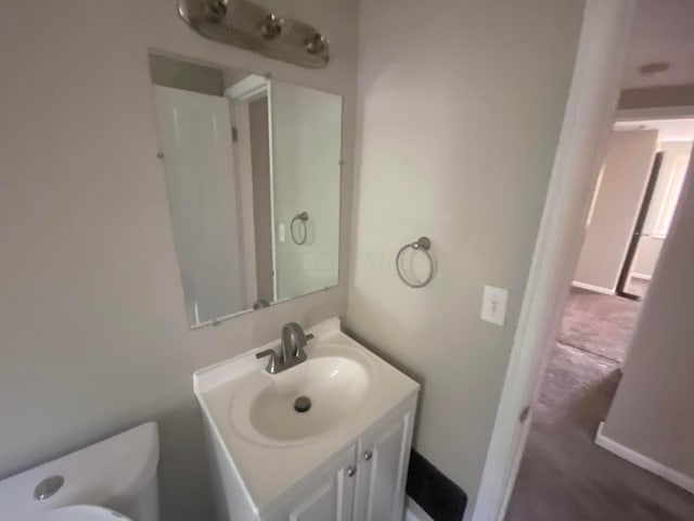 bathroom featuring hardwood / wood-style flooring, vanity, and toilet