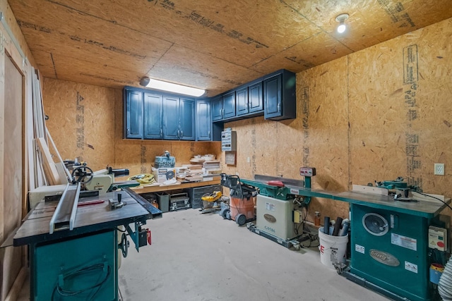 miscellaneous room featuring a workshop area and concrete floors