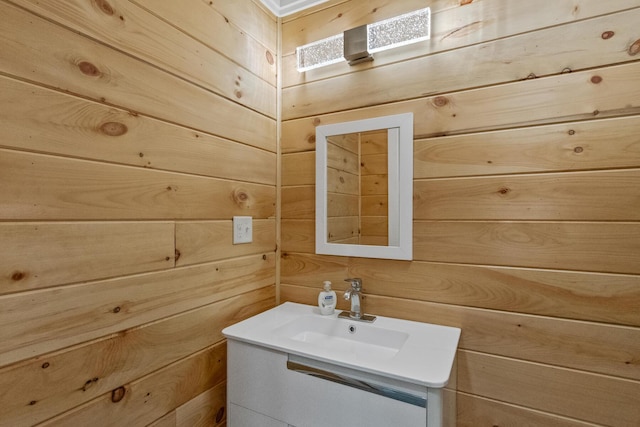 bathroom featuring vanity and wooden walls