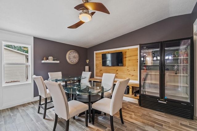 dining area featuring hardwood / wood-style floors, ceiling fan, and vaulted ceiling