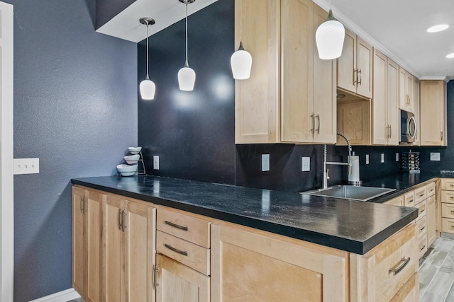 kitchen with light brown cabinets, decorative light fixtures, and sink