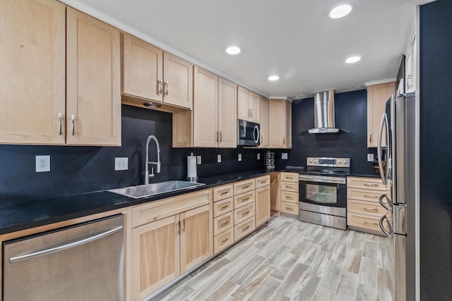 kitchen with light brown cabinetry, light wood-type flooring, wall chimney exhaust hood, stainless steel appliances, and sink