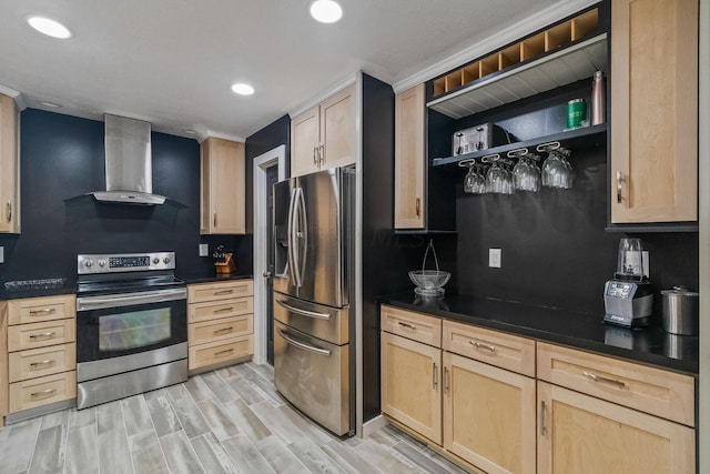 kitchen with wall chimney exhaust hood, stainless steel appliances, light brown cabinetry, and light hardwood / wood-style flooring