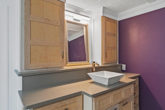 bathroom featuring a textured ceiling, vanity, and crown molding