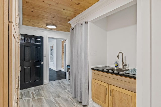 bar featuring wood ceiling, sink, light brown cabinetry, and light hardwood / wood-style flooring