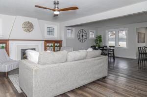 living room with ceiling fan and dark wood-type flooring