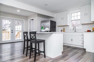 kitchen featuring white cabinets, french doors, stainless steel fridge, and a kitchen island