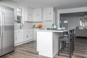 kitchen featuring hardwood / wood-style floors, white cabinets, sink, ceiling fan, and stainless steel fridge