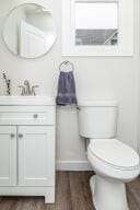 bathroom with hardwood / wood-style floors, vanity, and toilet