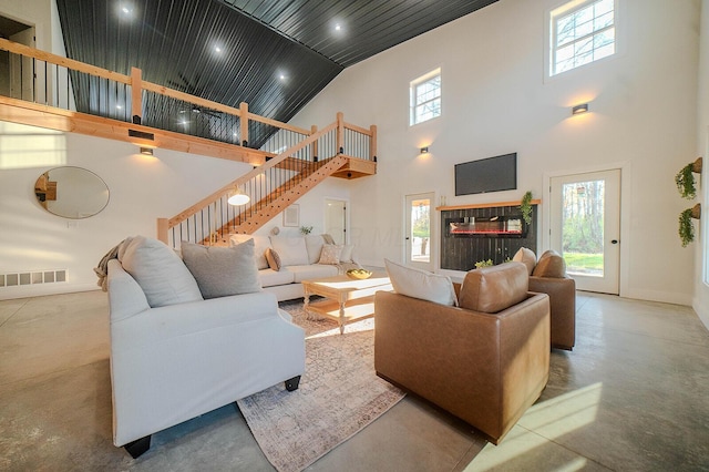 living room with high vaulted ceiling and a healthy amount of sunlight