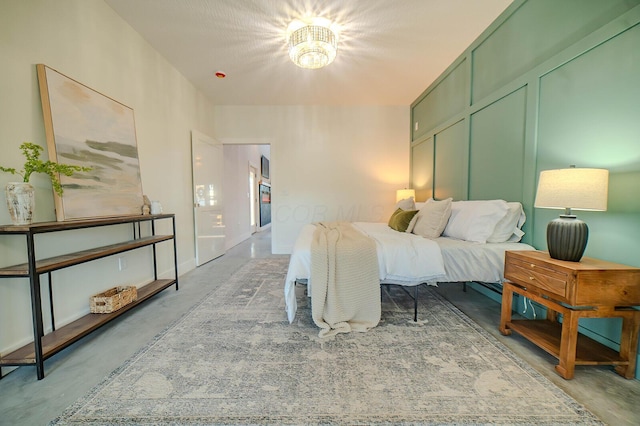 bedroom with a notable chandelier and concrete floors