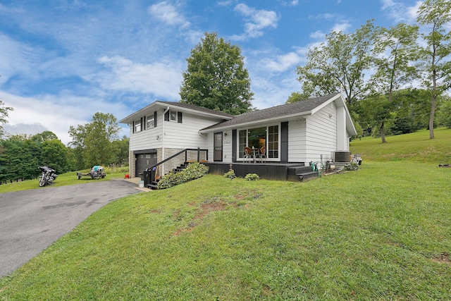 split level home featuring central AC, a front lawn, a porch, and a garage